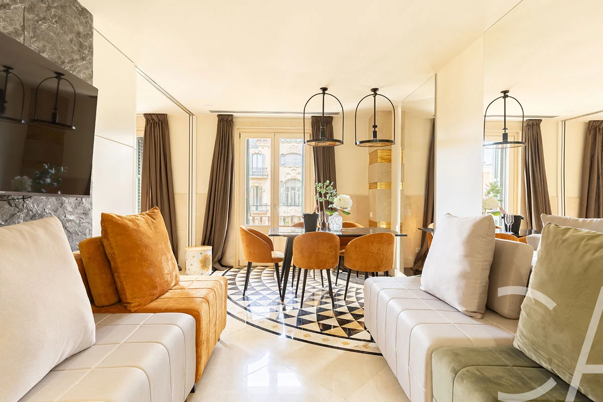 Spacieux salon de style Art déco, doté de canapés en cuir haut de gamme et d'une décoration élégante, situé dans un appartement de luxe à louer sur la Rambla Catalunya, dans le quartier de l'Eixample à Barcelone, en Espagne.