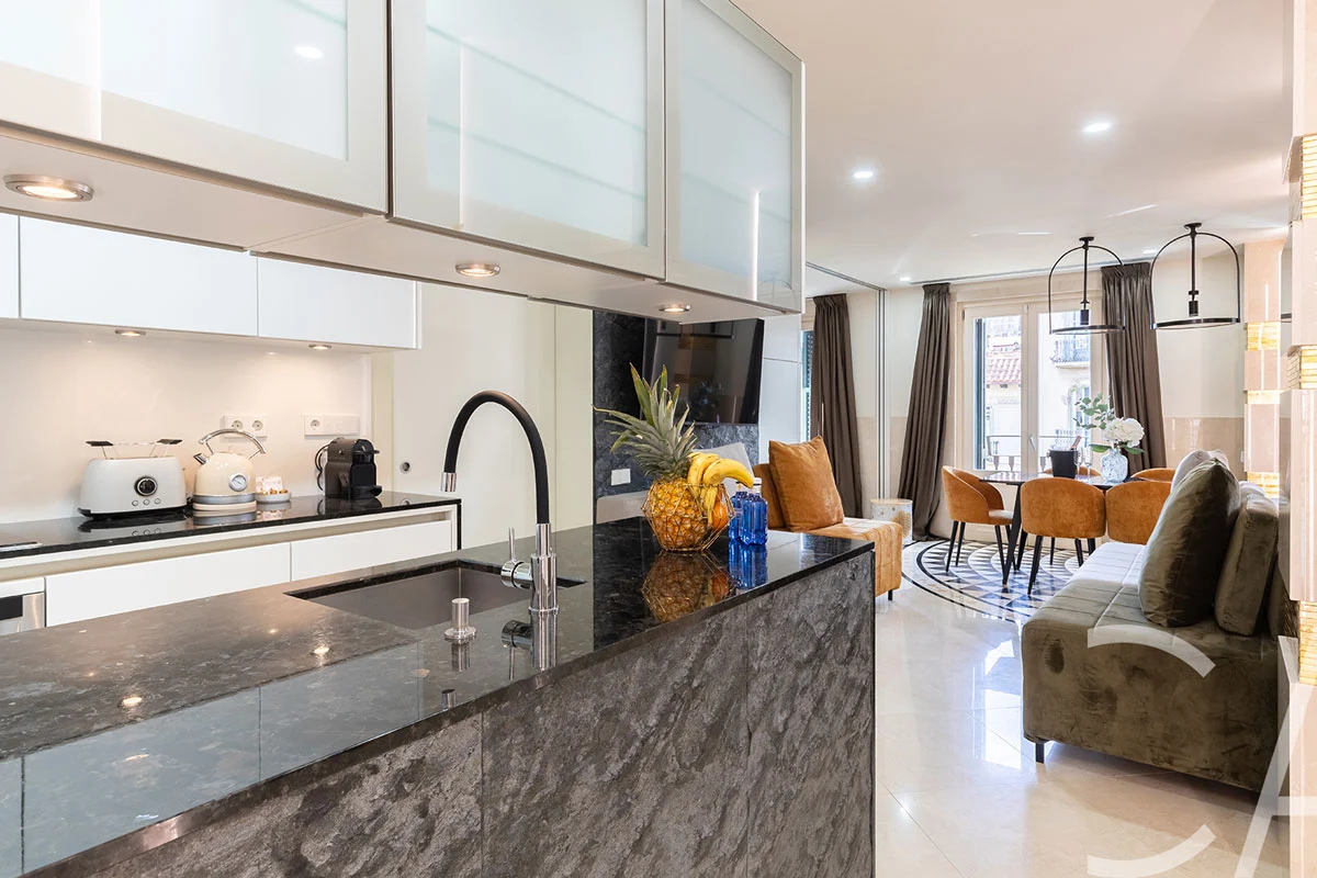 Élégant salon-cuisine ouvert, agrémenté de canapés en cuir, dans un appartement haut de gamme situé sur la Rambla Catalunya, à Barcelone, en Espagne.