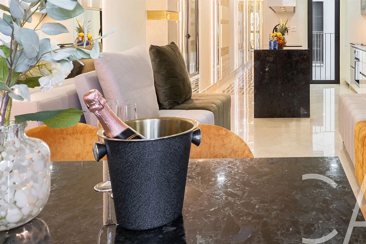 Élégant salon-cuisine ouvert, agrémenté de canapés en cuir, dans un appartement haut de gamme situé sur la Rambla Catalunya, à Barcelone, en Espagne — un cadeau de bienvenue vous est offert pour un séjour inoubliable.